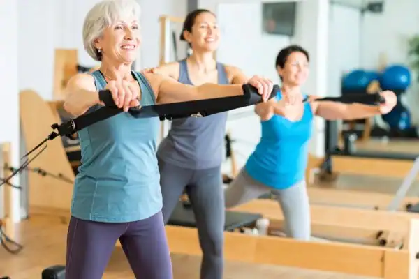 Toning Arms After 60: Empowering Womens Fitness Through Effective Weight Training 2 older woman doing weight training Braintree and resistance in the gym to tone upper arms