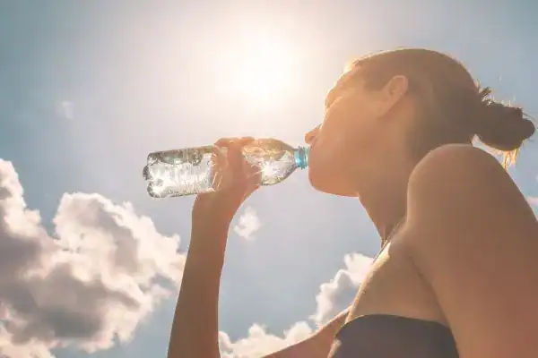 Hydration: The Secret Ingredient for a Toned Stomach and Enhanced Fitness 3 Image of woman drinking water to hydrate Braintree after run.